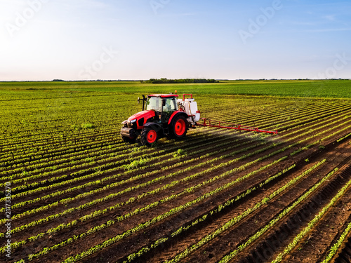 Red tractor spraying soybean field aerial crop protection