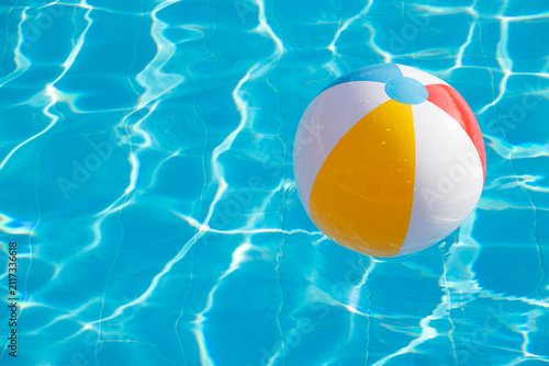 Fotografie Colorful inflatable ball floating in swimming pool