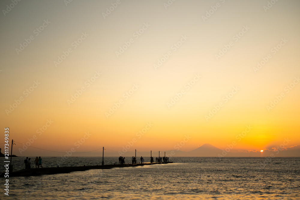 Fototapeta premium 夕焼けに染まる海と桟橋の風景