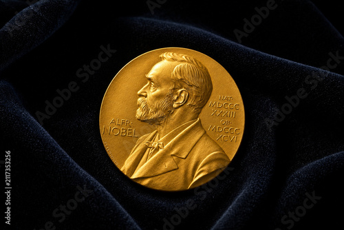 Nobel Prize medal on dark velvet, gleaming gold metal, achievement and honor.