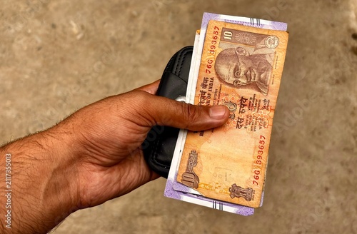 Foto Close Up of Hand Holding Indian Banknotes and Rupees Concept for Falling GDP Eco
