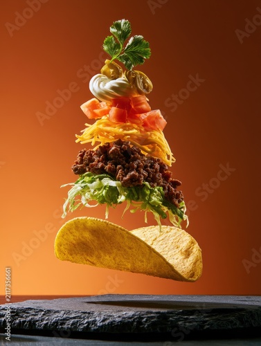 Deconstructed taco layers suspended in air, showcasing fresh ingredients