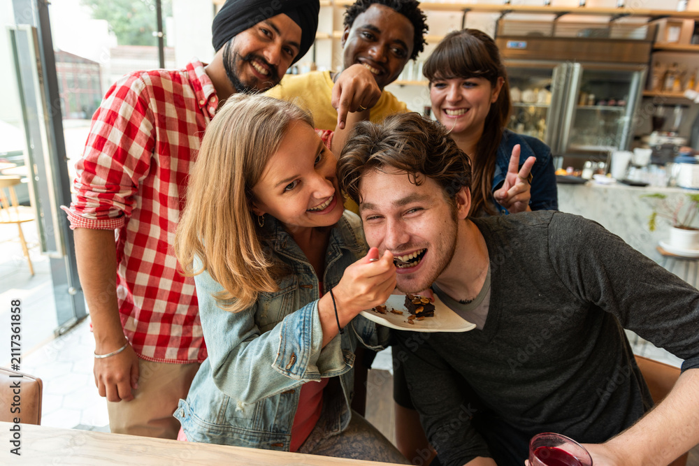 Obraz premium Group of friends enjoying dessert together in a cafe setting.