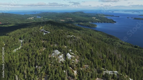 Aerial view of Koli National Park with dense coniferous forests, rocky terrain, and the expansive Lake Pielinen in Koli, Pohjois-Karjala, Finland.