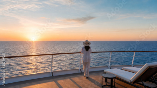 Woman ocean sunset cruise deck hat sea horizon leisure travel vacation water sky sunlight outdoors relaxation summer horizon line person standing