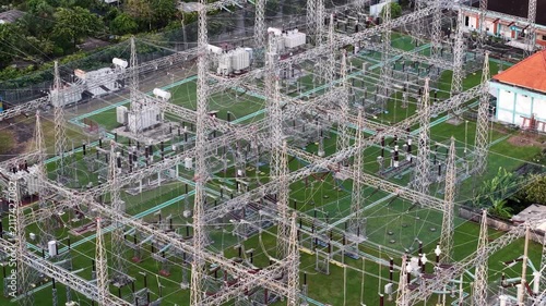 Aerial view of Gardu Induk Sanur electrical substation with metal towers and power lines in Kecamatan Denpasar Selatan, Bali, Indonesia.