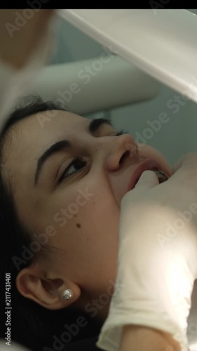 Orthodontist examining patient's dental braces in clinic