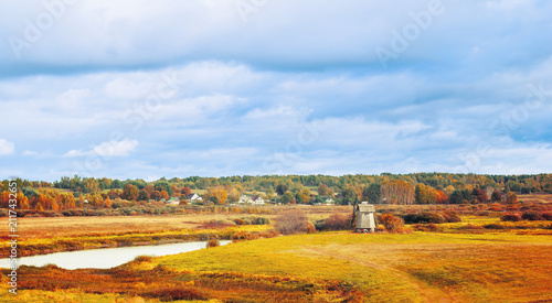 Картината върху платно Autumn countryside landscape - a traditional old wooden windmill standing near t