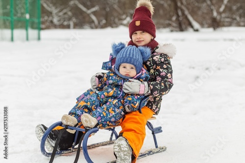 Konstfotografi Children riding sled together in snowy winter park