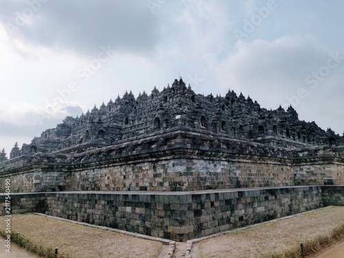 Bild auf Leinwand borobudur temple massive ancient stone structure stand wide corner view cloudy s