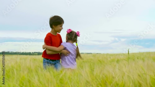 Sibling Little Kids Having Fun in the Summer Meadow. Boy and Girl Holding Hands and Spinning in a Field. Carefree Childhood Concept. Summertime