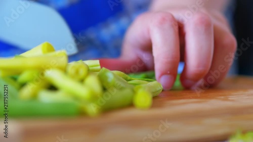 close-up detail of freshly chopped green and yellow string beans on a wooden cutting board