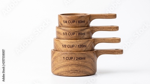 Stacked wooden measuring cups on white. Kitchen tools for baking and cooking ingredients.