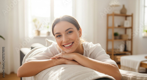 Smiling woman resting head on hands while relaxing on couch, perfect for domestic comfort lifestyle concepts and peaceful living