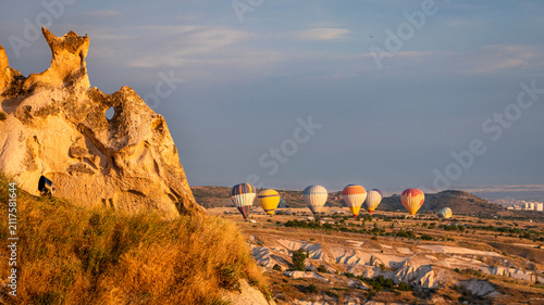 Obraz na płótnie Cappadocia Hot Air Balloon Flying Over Rock Formation at Golden Hour with Clear Blue Sky
