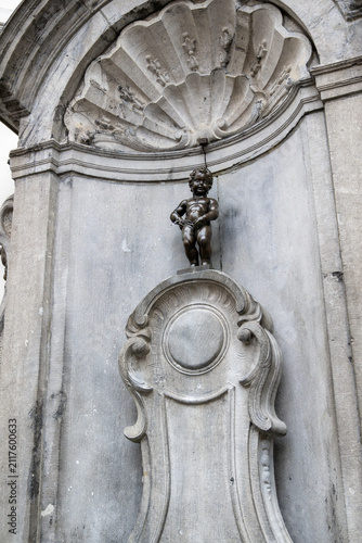 Famous Manneken Pis fountain statue in the historic center of Brussels, Belgium, attracting visitors as one of the city's most iconic cultural and tourist landmarks.