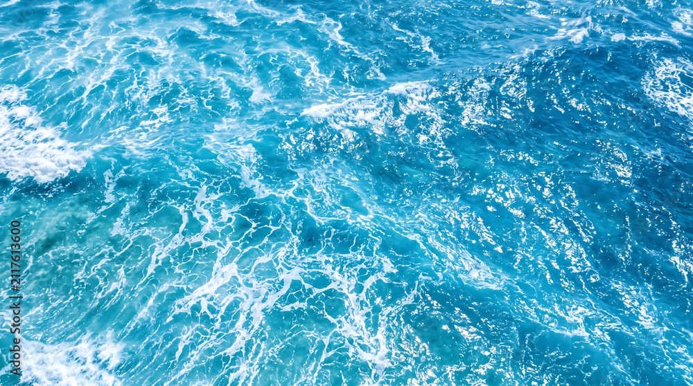 Fototapeta premium Aerial view of deep blue ocean waves with white sea foam splashing in sunlight