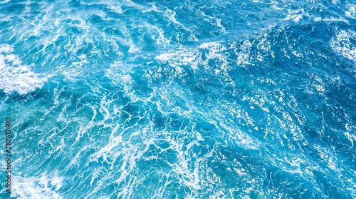 Fotografie Aerial view of deep blue ocean waves with white sea foam splashing in sunlight