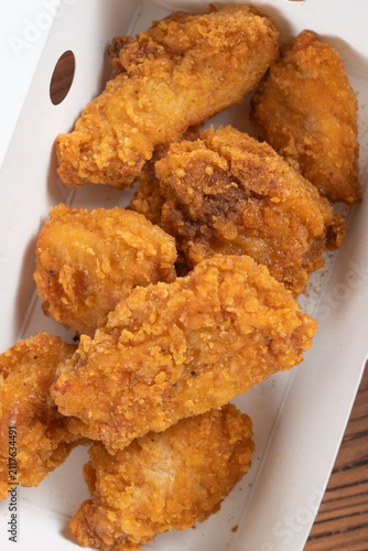 Crispy salt pepper fried chicken pieces placed inside a white paper takeaway box