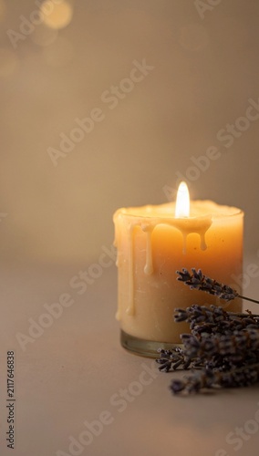 aromatic candle with dried lavender beside it, soft warm flame glow, calming and cozy atmosphere, detailed wax texture, negative space on the left