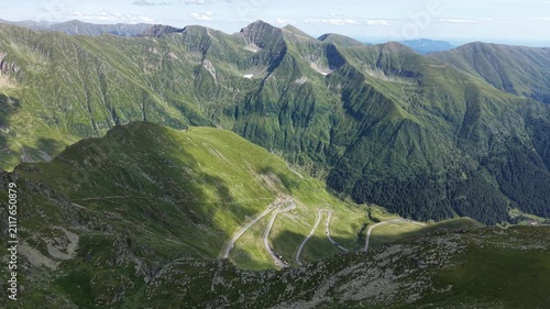 Forward drone flight above the spectacular Transfăgărășan highway revealing winding mountain roads, dramatic peaks and the vast Romanian landscape beyond.