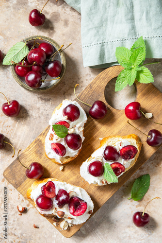 Canvas Print Bruschetta with ricotta, cherry and nuts on a stone tabletop