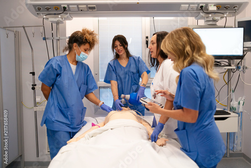 Naklejka Nurses learning cpr on dummy during medical simulation training