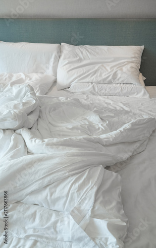 close up on messy bed in the hotel bedroom