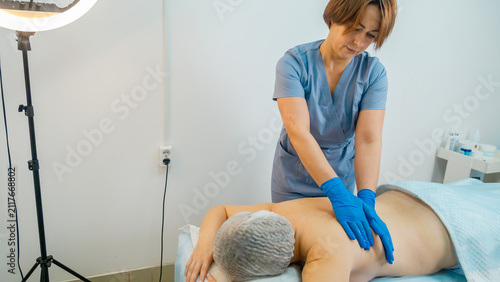 Fotografie Masseuse doing a therapeutic relaxing back massage to a girl in the spa