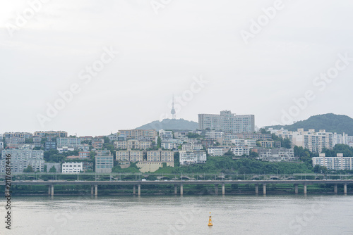 Принти на полотні Modern Cityscape with River and Tower Overcast Sky General View