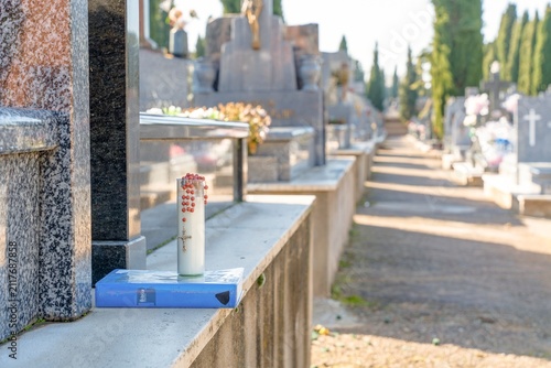 Obraz na płótnie Religious candle and rosary on tombstone in cemetery