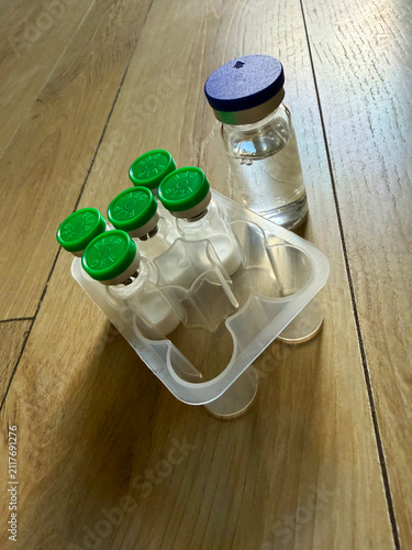 Reta, retatrutide peptide in a vial and bacteriostatic water on a wooden background.	