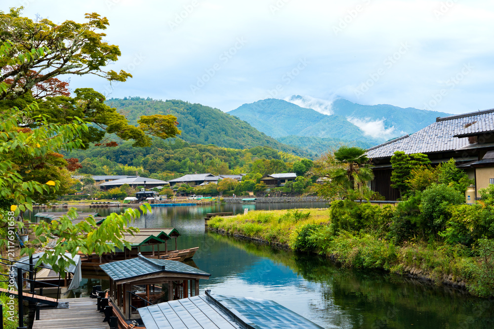 Fototapeta premium Scenic View of Traditional Wooden Boats on Katsura River with Mountains in Arashiyama, Kyoto, Japan