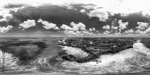 Drone spherical view of Pura Batu Bolong with ocean, cliffs, and temple architecture in black and white