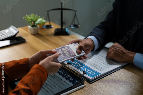 Obraz na plátne Businessman secretly giving money bribe to law officer or partner under a contract agreement