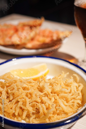 Obraz na płótnie Crispy fried whitebait chanquetes with pan con tomate in background, traditional
