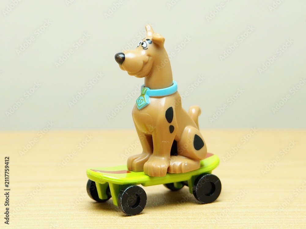 Fototapeta premium Indonesia - February 10, 2026 : Mini toy of action figure at outdoor with blur background. Miniature photography concept design. Minifigure of Scooby character playing skate board at sport arena.