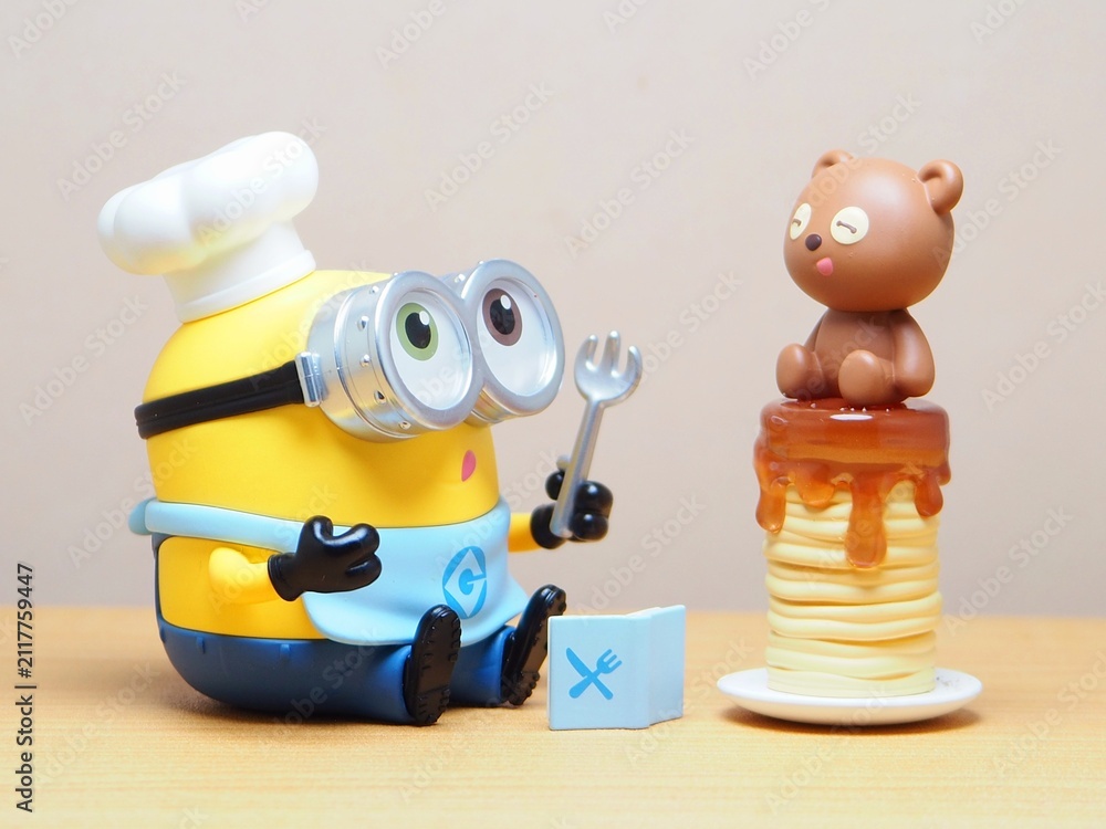 Naklejka premium Indonesia - February 22, 2026 : Mini toy of action figure at outdoor with blur background. Miniature photography concept design. Minifigure of Minions character from Despicable Me film as a chef.