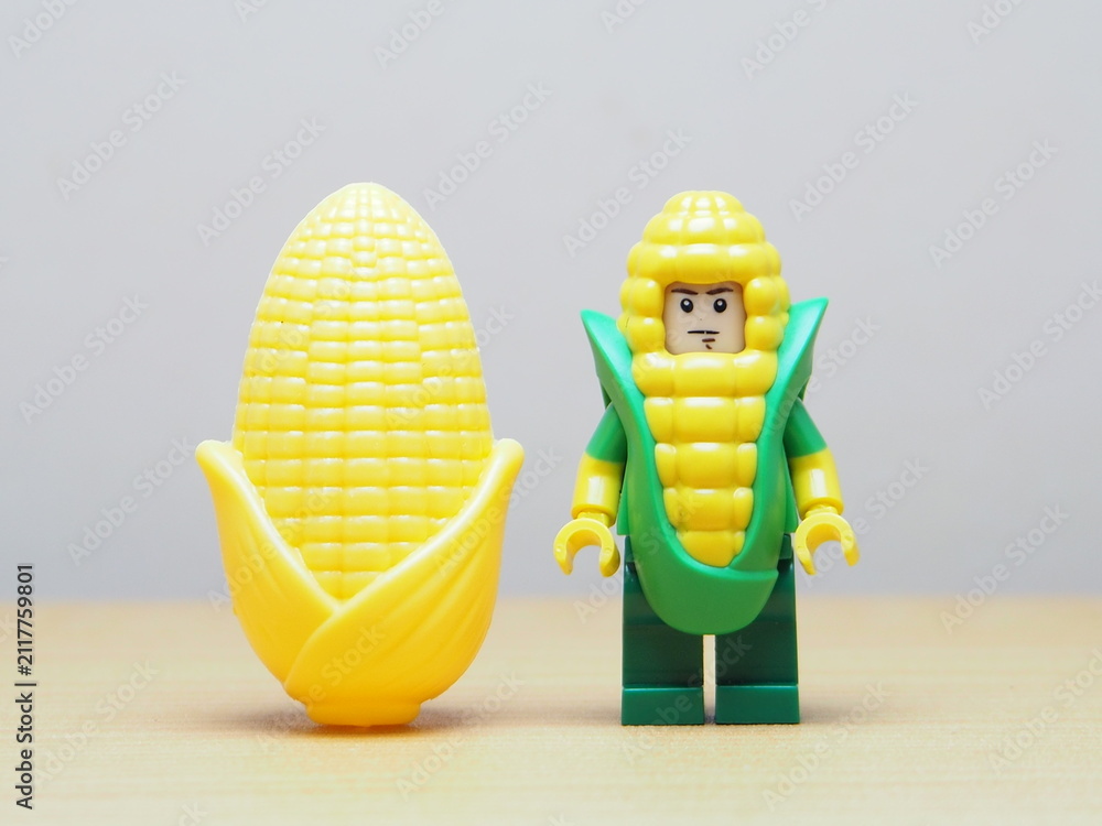 Fototapeta premium Indonesia - February 10, 2026 : Mini toy of action figure at outdoor with blur background. Miniature photography concept design. Minifigure of corn guy character with corn cob at garden.