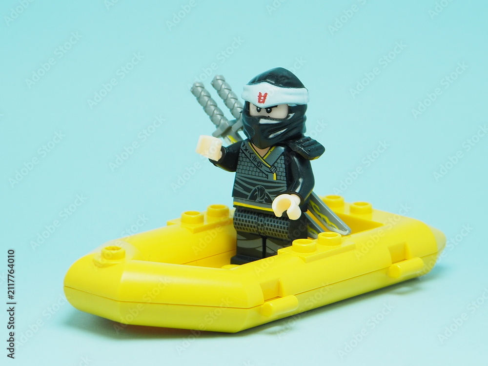 Fototapeta premium Indonesia - December 4, 2025 : Mini toy of action figure at outdoor with blurred background. Miniature photography concept design. Minifigure of Ninja Go character sailing with rubber boat at ocean.