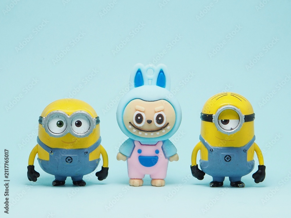 Fototapeta premium Indonesia - November 3, 2025 : Mini toy of action figure at outdoor with blurred background. Miniature photography concept design. Minions character from Despicable Me Cartoon film and Labubu doll.