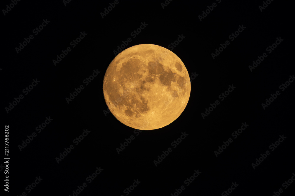 Obraz premium Close up of a detailed golden full moon isolated on black night sky background