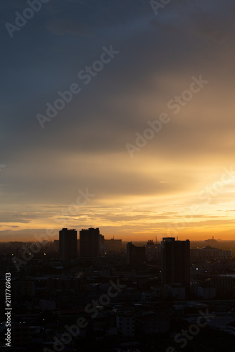 Sunset cityscape skyline silhouette cloud dusk urban tower warm sky over dark building silhouette and hazy metropolitan horizon