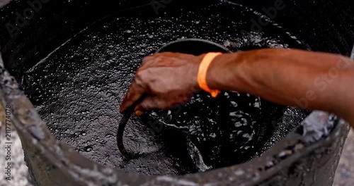 Workers Heating Hot Bitumen in a Metal Drum for Rural Road Construction and Maintenance, vertical and horizontal video