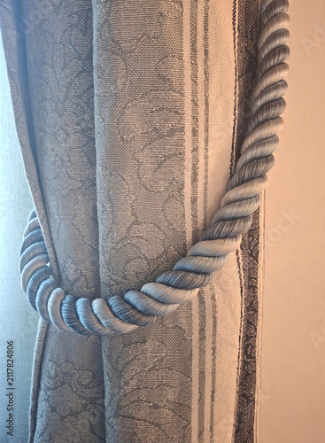 close-up, homey view of a cord holding a damask curtain