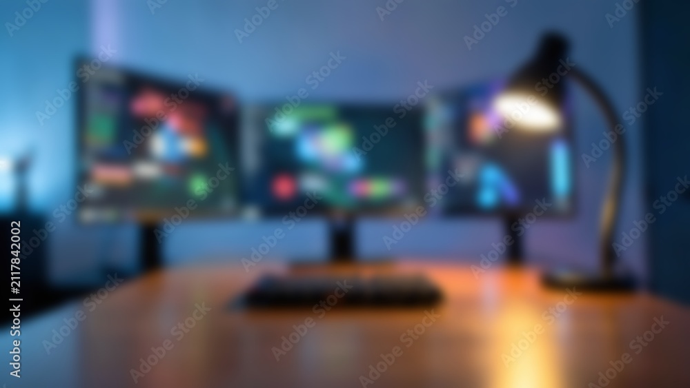 Obraz premium Blurred Modern Triple Monitor AI Workstation for Technology Website