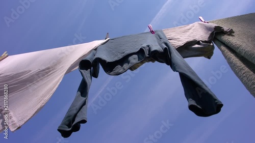 Laundry hangs on the washing line on clear blue sky day