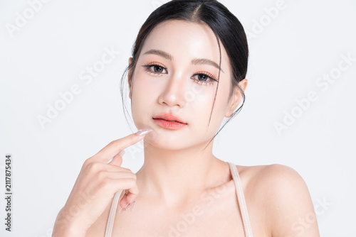 Closeup beautiful young Asian woman with glowing makeup and healthy facial skin, isolated on white background.