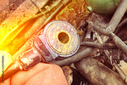 Close view of a damaged car part showing cracks and dirt from a repair setting