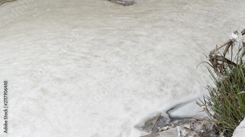 White mineral surface with natural undulating patterns and texture of salt or calcareous deposits. Foam of sewage and waste water. Environmental pollution. Abstract natural background with smooth line